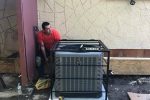 HVAC technician installing a central air conditioner in a San Antonio home